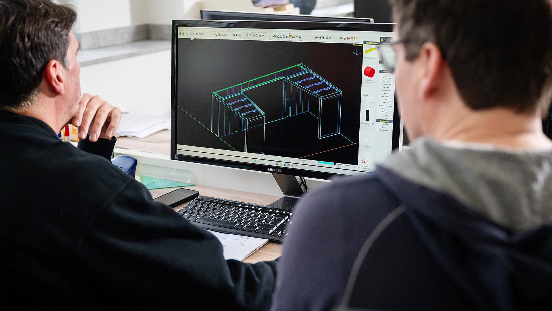 MA Messebau Header Konzeption zwei Mitarbeiter arbeiten konzentriert an einer Messestand Visualisierung