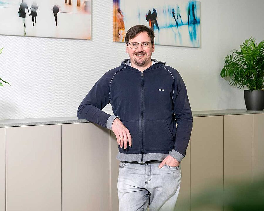 MA Messebau Matthias Albert lehnt an einem Sideboard und blickt in die Kamera