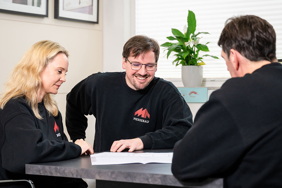 MA Messebau Besprechungsszene Messestand 3 Mitarbeiter