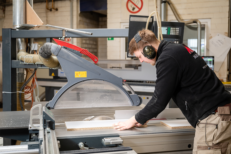 MA Messebau Mitarbeiter beim Holzzuschnitt